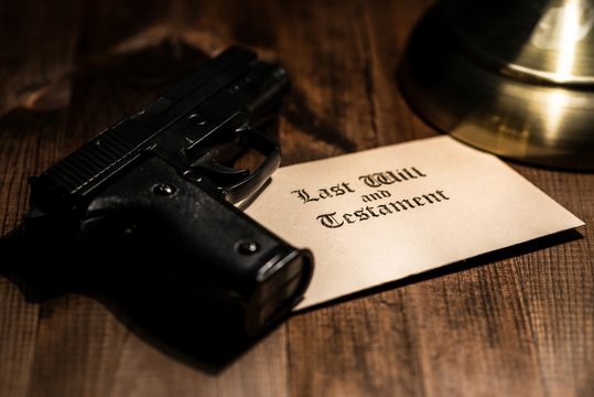 Pistol and testament on desk