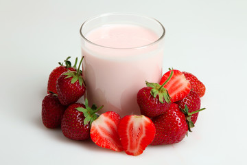 ripe delicious strawberries near the glass Cup with yogurt on white isolated background