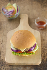  burger on a light rustic wooden board