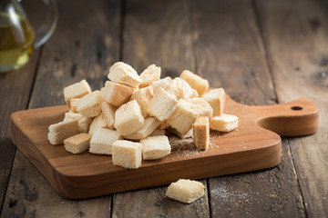 homemade croutons from white bread in wood on old wood table
