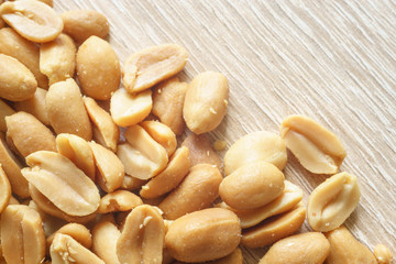 Roasted salted peanuts on wooden background