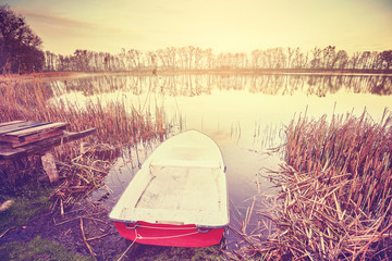 Vintage toned boat by a lake at sunrise © MaciejBledowski
