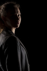 portrait of a girl with the face in shadow on a dark background