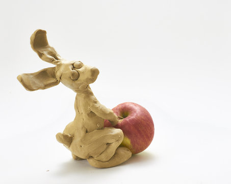 Funny Bunny Doll Drags An Apple. Small Figure With A Big Fruit.