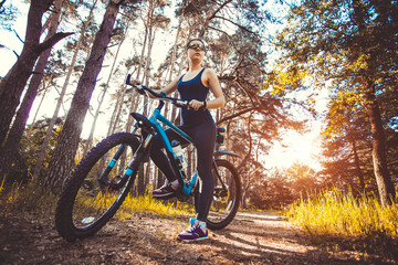 Fototapeta na wymiar woman cyclist rides in the forest on a mountain bike.