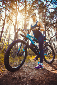 woman cyclist rides in the forest on a mountain bike.