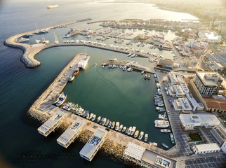 Obraz premium Aerial view of fishing boats docked at the Limassol old port (palio limani) in Cyprus, next to the Marina part of the ports authority. The harbor, Mediterranean sea,water, restaurants and coffee shops