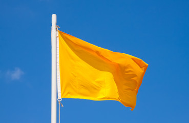 Yellow signal flag at sky background