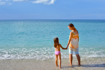 Naklejka premium Adorable toddler girl enjoying her summer vacation at beach with