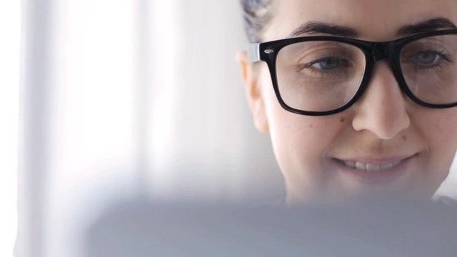 young woman in eyeglasses with tablet pc at home