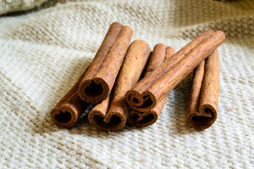 Spices cinnamon sticks on the cloth on a wooden table