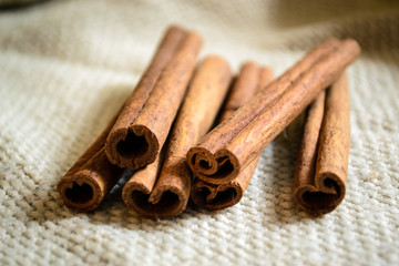 Spices cinnamon sticks on the cloth on a wooden table