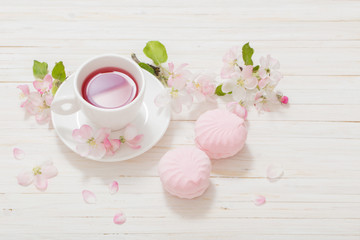 Red tea with flowers on white wooden background