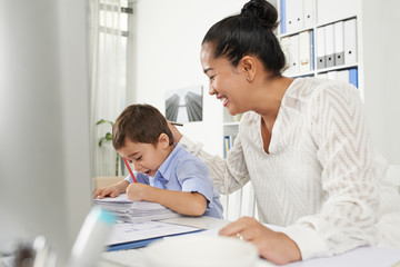 Obraz premium Little boy drawing when waiting for his mother in office