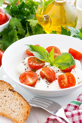 fresh salad with mozzarella and cherry tomatoes, vertical