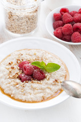 oatmeal with raspberries and honey, vertical, close-up