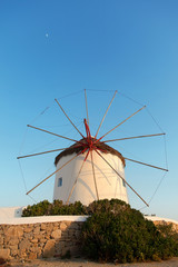 Fototapeta na wymiar Windmill in front of a blue sky in Mykonos island, Greece at sunset. Vertical shot.