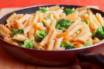 Penne with broccoli and cream, cooked in frying pan. Vertical shot