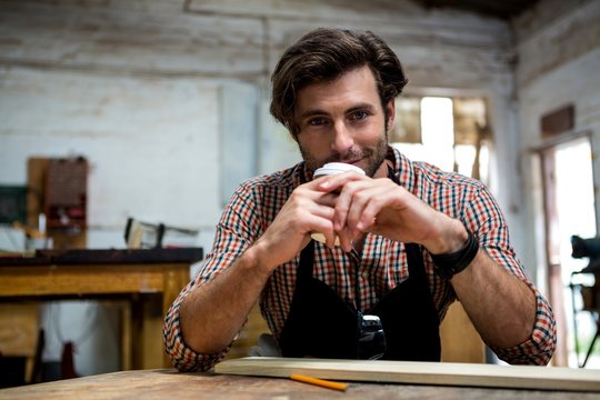 Carpenter Is Posing With His Craft And His Coffee