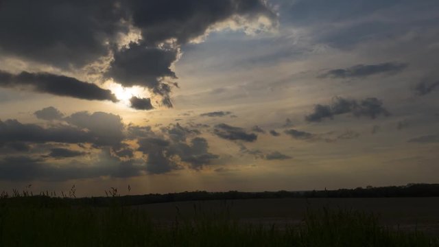 Sun rays streaming down through clouds - time lapse