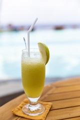 Glasses of color cocktails on pool background