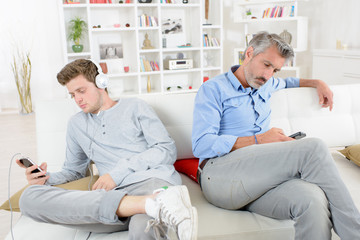 Fototapeta premium Adult and adolescent independetly using their electronic devices
