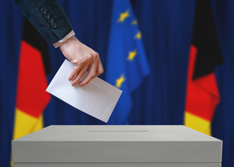 Election in Germany. Voter holds envelope in hand above vote ballot. German and European Union...