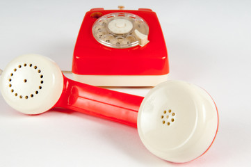 Retro orange telephone with rotary dial on white