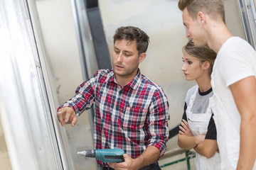 Obraz premium Young apprentice with professionnal plasterer