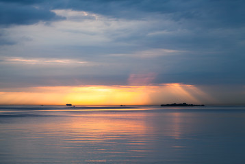 Fototapeta na wymiar Sunset over Baltic Sea. Cloudy sky, still water