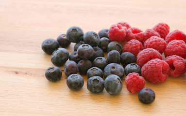 Blueberries and raspberries on a wooden background