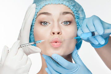 Attractive woman at plastic surgery with syringe in her face