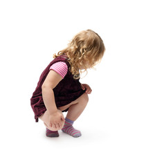 Young little girl sitting over isolated white background