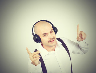 mustache businessman listening to music on headphones and sings