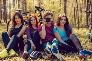 Group of cyclist taking pictures in summer forest.