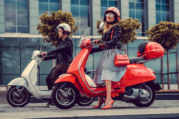 Obraz na płótnie Canvas Male and female having fun on moto scooters.