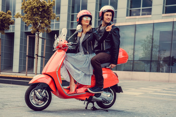 Male and female having fun on moto scooter.