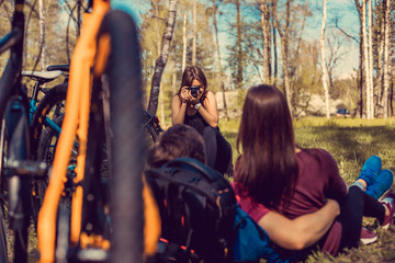Fototapeta na wymiar Female photographer shooting sporty couple after bicycle riding.