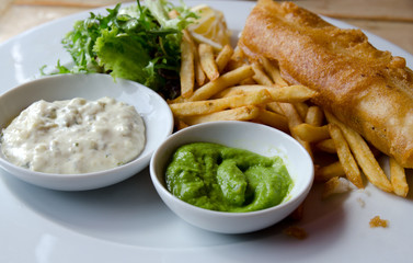 A meal of fish and chips with mushy peas
