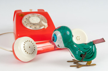 Retro orange telephone with rotary dial on white
