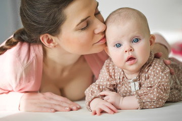 Happy mother with her baby on the badroom