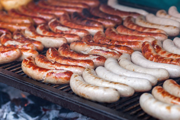 rows of bratwurst on a large grill
