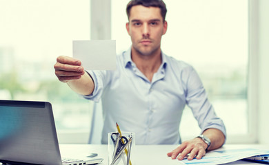 businessman showing blank paper card at office