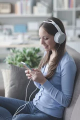 Foto op Plexiglas Girl listening to music with her smartphone © stokkete