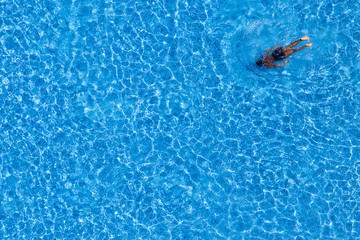 Man swim in the pool at the hotel. View from above.