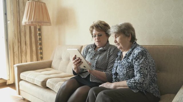 The old woman and her friend looking at pictures