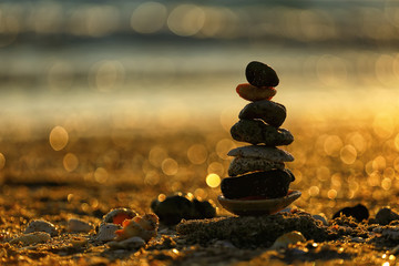 Balancing stones stacked on top of each other at sunset, spa concept 