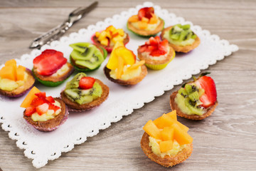 mini pastry with custard cream and melon in focus in the foregro