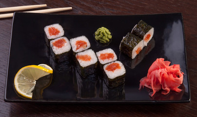 sushi roll on a plate with ginger and lemon