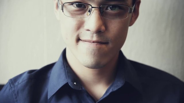 Portrait of Handsome Chinese-Thai  Asian male in dark blue shirt with smile face looking at camera   cinematic tone